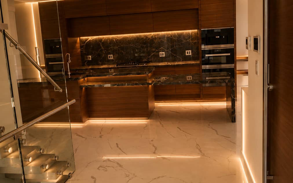 Renovated kitchen and stair hall with continuous stone flooring